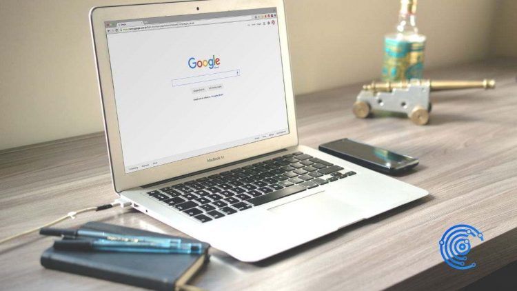 Portátil sobre un escritorio de trabajo con la web de Google en la pantalla