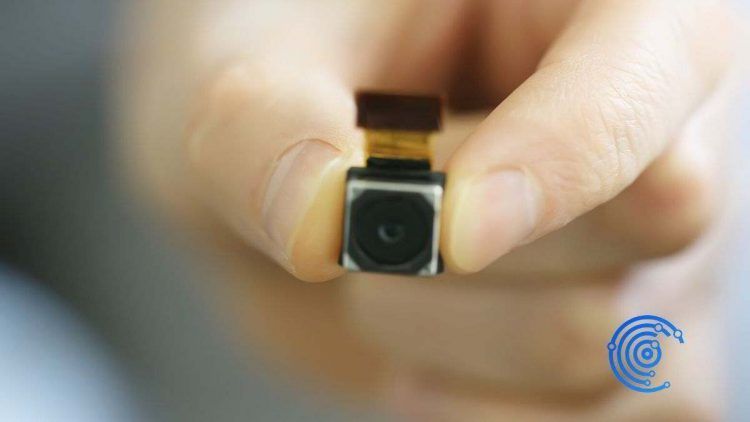 Mano sujetando una mini cámara espía