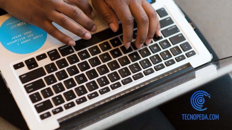 Persona escribiendo en el teclado de un portátil