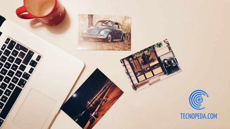 Fotografías sobre una mesa junto a un portátil