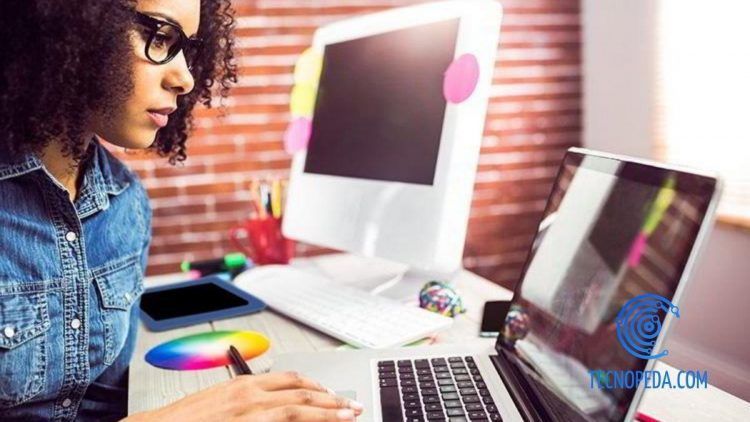 Mujer con gafas trabajando con un portátil