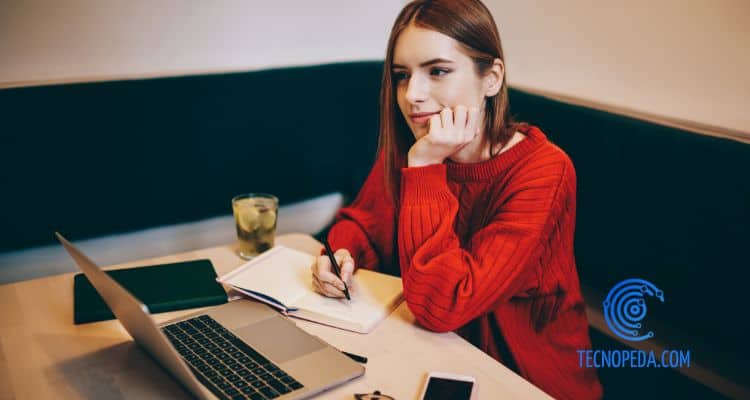 Joven realizando trabajos universitarios en una cafetería
