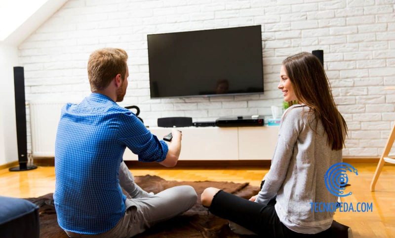Pareja viendo la televisión en el salón
